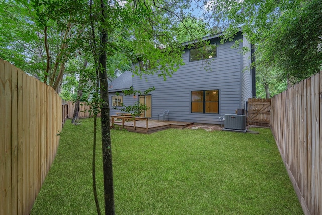 back of property featuring a lawn, a fenced backyard, a deck, and cooling unit