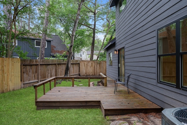 wooden terrace with a lawn, central AC unit, and a fenced backyard