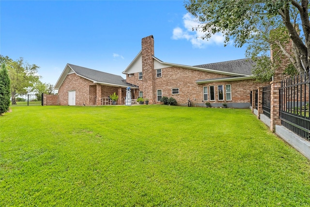 466 Buffalo Ct, Livingston, TX 77351 - rear view of house with fence, a chimney, brick siding, and a yard