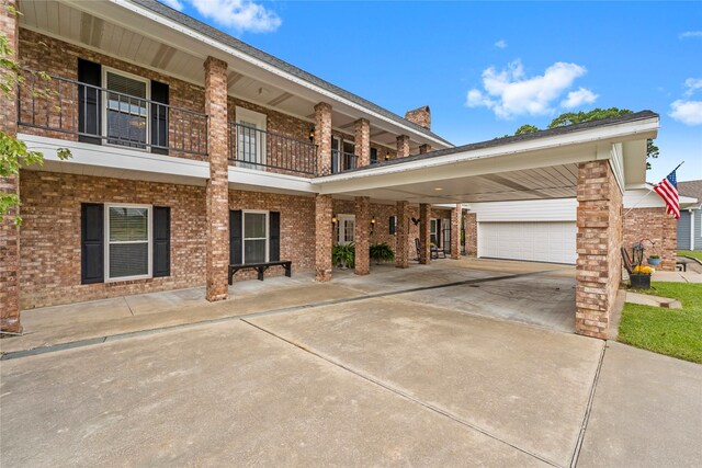 466 Buffalo Ct, Livingston, TX 77351 - view of front of house with an attached garage, brick siding, driveway, and a balcony
