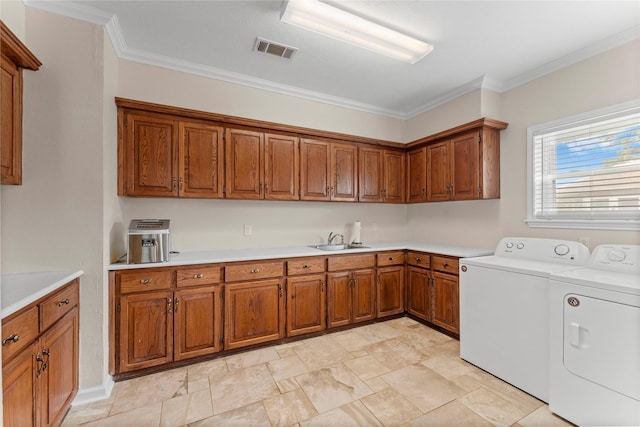 466 Buffalo Ct, Livingston, TX 77351 - laundry room featuring crown molding, a sink, washing machine and dryer, stone finish floor, and visible vents