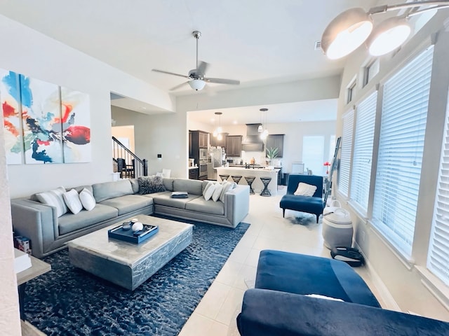 living room featuring light tile patterned floors, stairway, and a ceiling fan