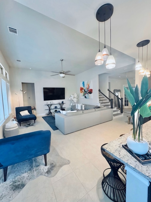 living room featuring tile patterned flooring, ceiling fan, and visible vents
