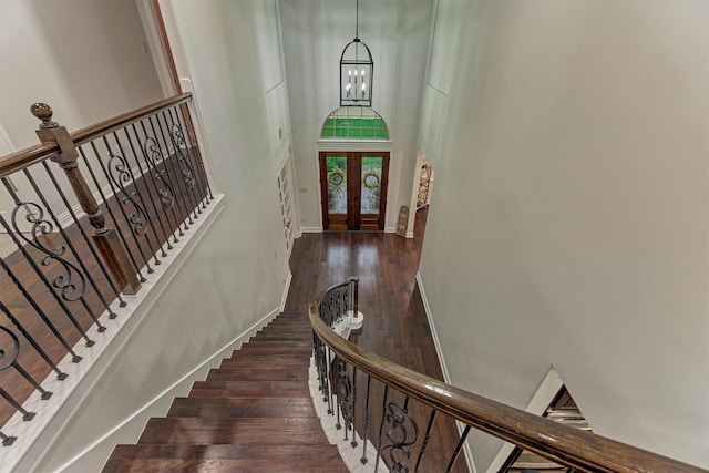 21603 Fairhaven Creek Dr, Cypress, TX 77433 - stairway featuring a towering ceiling, wood finished floors, a chandelier, french doors, and baseboards