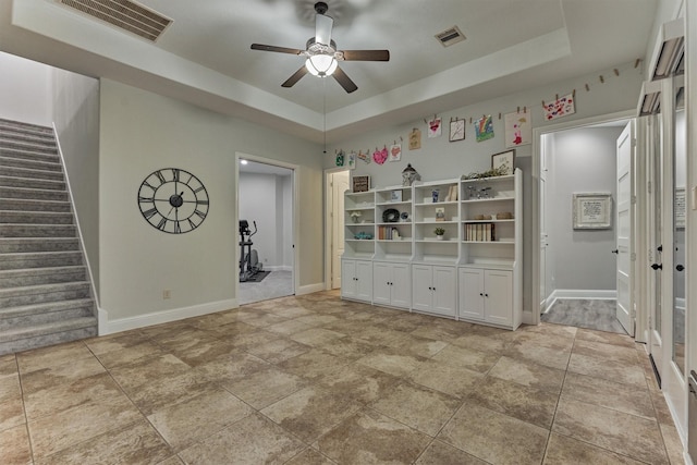 21603 Fairhaven Creek Dr, Cypress, TX 77433 - empty room featuring a ceiling fan, a tray ceiling, stairs, and baseboards