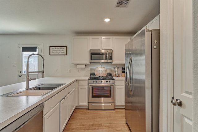 kitchen with light countertops, visible vents, a sink, and appliances with stainless steel finishes
