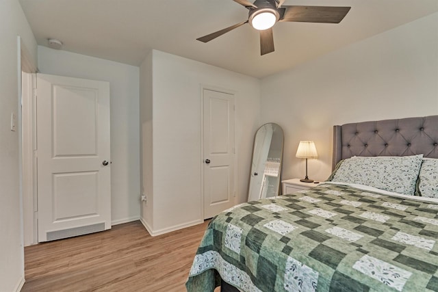 bedroom featuring ceiling fan, baseboards, and light wood finished floors