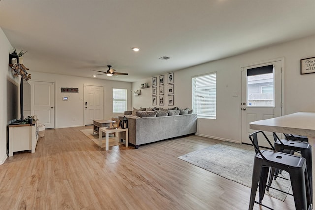 living room featuring recessed lighting, visible vents, a ceiling fan, baseboards, and light wood-style flooring