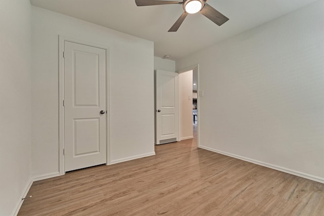unfurnished bedroom featuring light wood-type flooring, baseboards, and ceiling fan