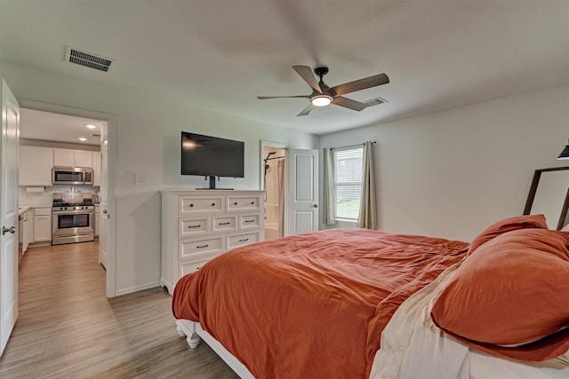 bedroom with light wood finished floors, a ceiling fan, and visible vents