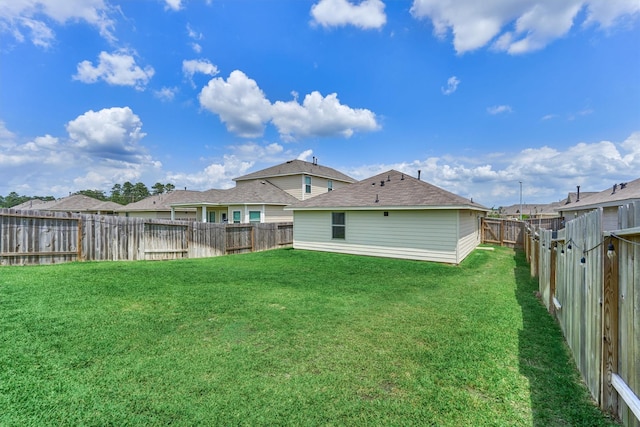 back of house featuring a fenced backyard and a yard