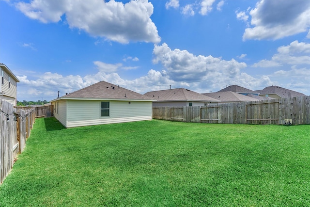 back of house featuring a lawn and a fenced backyard
