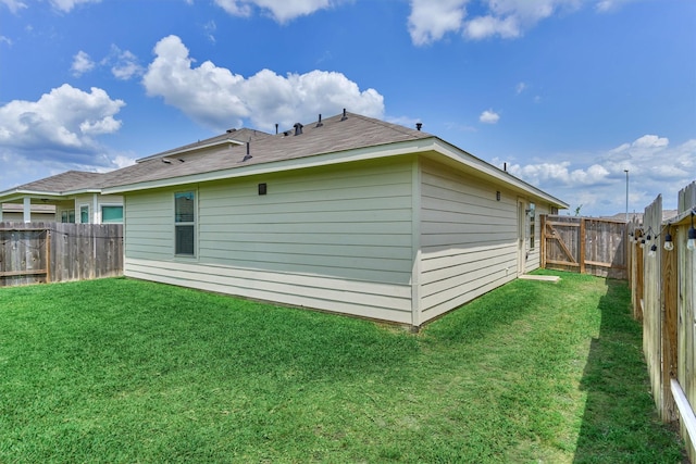 rear view of property featuring a fenced backyard and a yard
