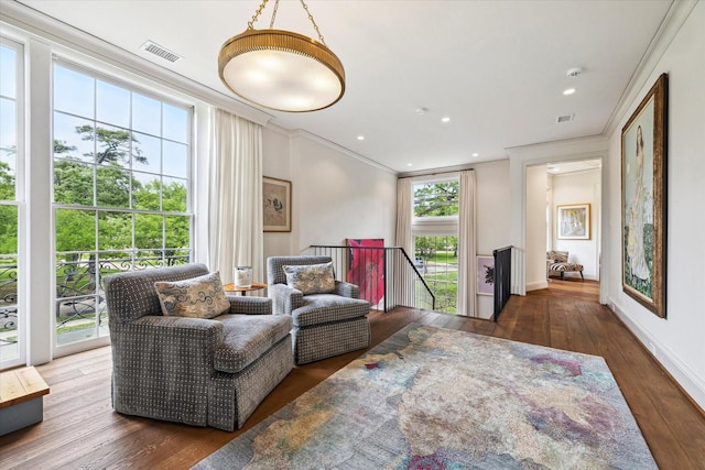 living area with visible vents, crown molding, recessed lighting, and wood-type flooring