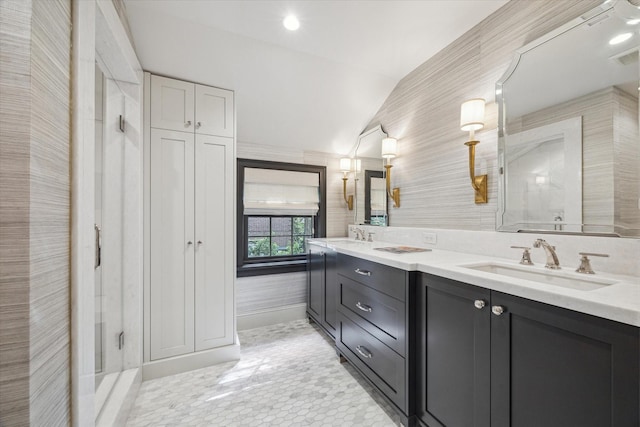 full bath with lofted ceiling, double vanity, and a sink