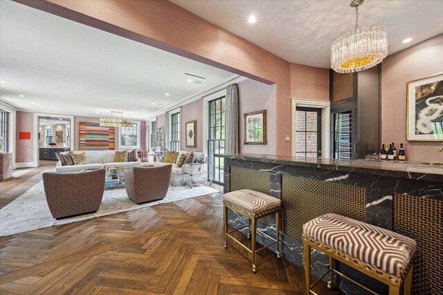 interior space featuring recessed lighting, a notable chandelier, bar, and pendant lighting