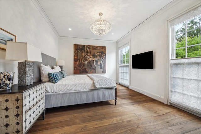 bedroom featuring an inviting chandelier, crown molding, dark wood finished floors, and baseboards