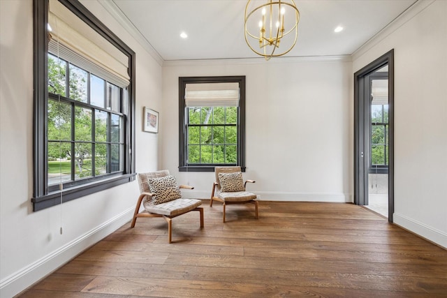 sitting room with ornamental molding, a healthy amount of sunlight, and a notable chandelier
