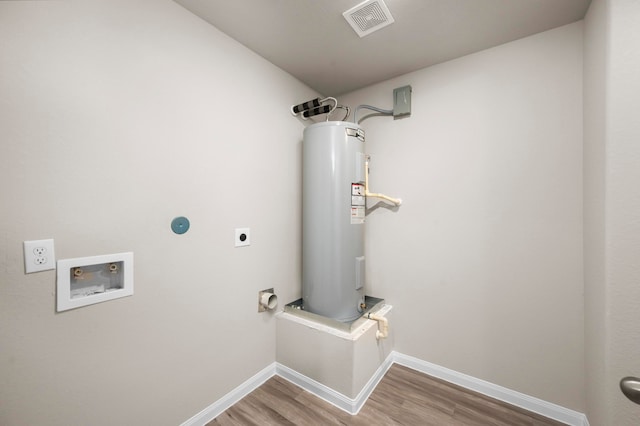 310 N Orange St, Sweeny, TX 77480 - laundry room with electric dryer hookup, electric water heater, washer hookup, wood finished floors, and baseboards