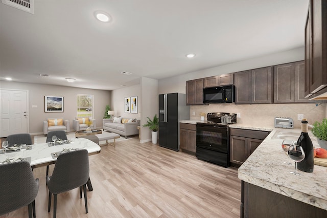 310 N Orange St, Sweeny, TX 77480 - kitchen featuring black appliances, dark brown cabinetry, light countertops, open floor plan, and backsplash