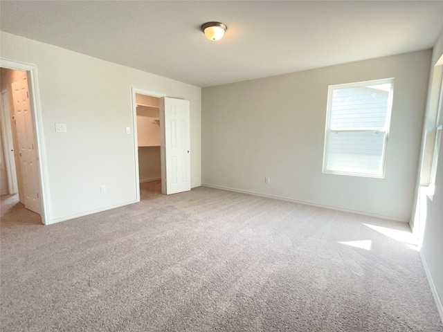 310 N Orange St, Sweeny, TX 77480 - unfurnished bedroom featuring carpet floors, a spacious closet, baseboards, and a closet