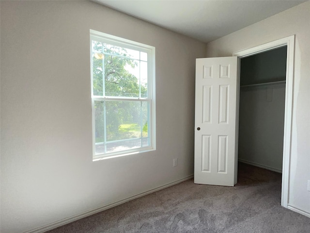 310 N Orange St, Sweeny, TX 77480 - unfurnished bedroom featuring multiple windows, carpet flooring, a spacious closet, and a closet