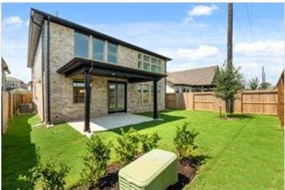401 Wild Thicket Dr, Katy, TX 77493 - back of property featuring stone siding, a patio area, and a fenced backyard