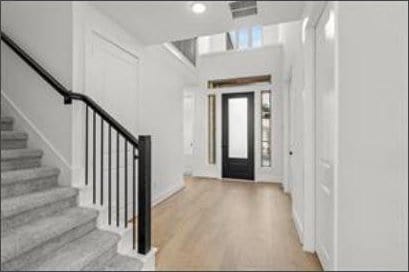 401 Wild Thicket Dr, Katy, TX 77493 - foyer featuring stairs and wood finished floors