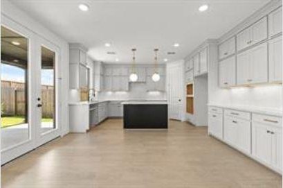 401 Wild Thicket Dr, Katy, TX 77493 - kitchen with a center island, recessed lighting, light countertops, decorative light fixtures, and light wood finished floors