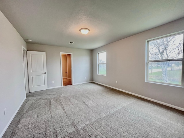 306 N Orange St, Sweeny, TX 77480 - unfurnished bedroom featuring carpet, baseboards, and a textured ceiling