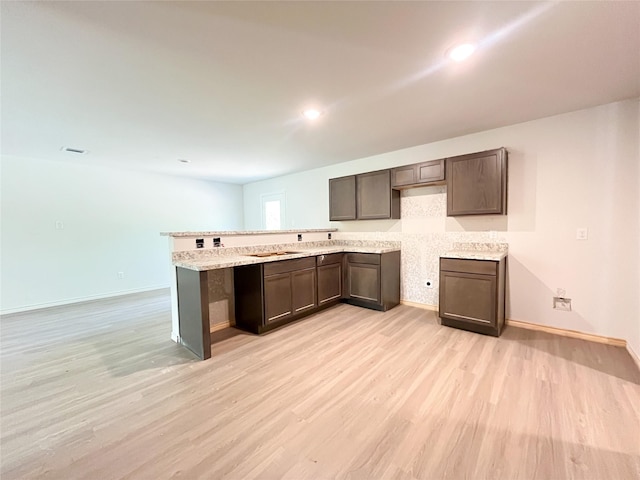 306 N Orange St, Sweeny, TX 77480 - kitchen featuring light wood-style flooring, baseboards, a peninsula, and recessed lighting