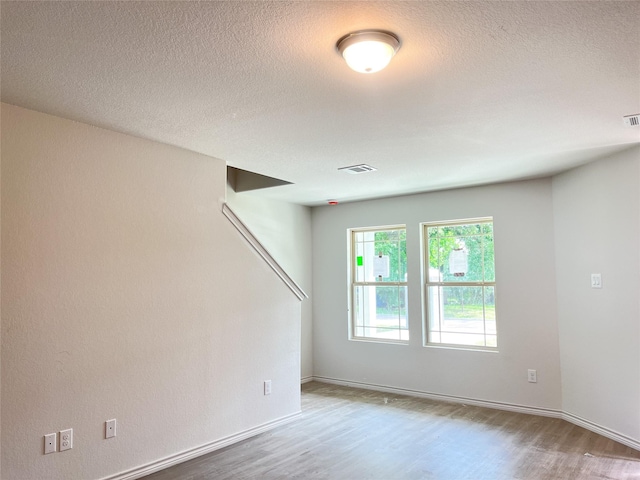 306 N Orange St, Sweeny, TX 77480 - empty room with wood finished floors, a textured ceiling, and baseboards