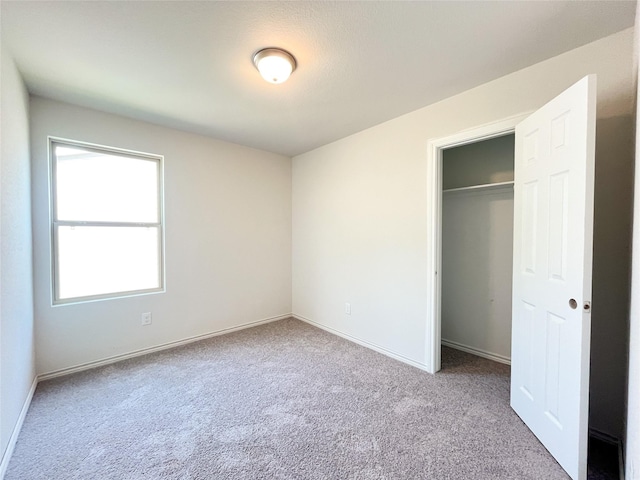 306 N Orange St, Sweeny, TX 77480 - unfurnished bedroom featuring carpet, a closet, and baseboards