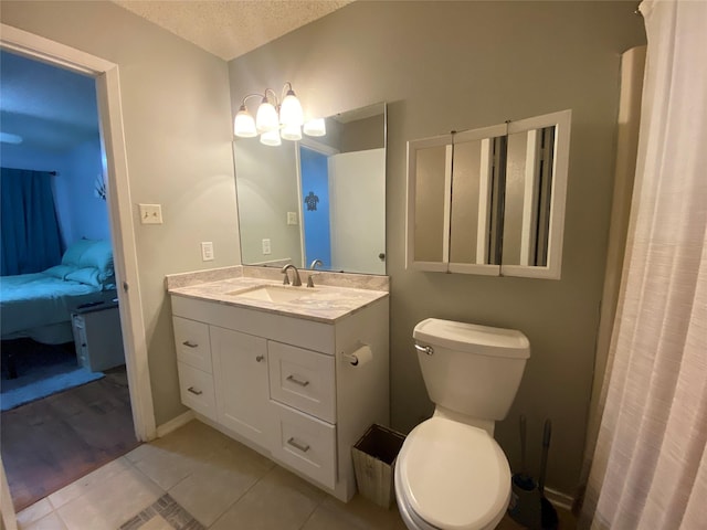 28604 Magnolia Ct, Huntsville, TX 77320 - ensuite bathroom featuring tile patterned floors, a textured ceiling, toilet, vanity, and connected bathroom