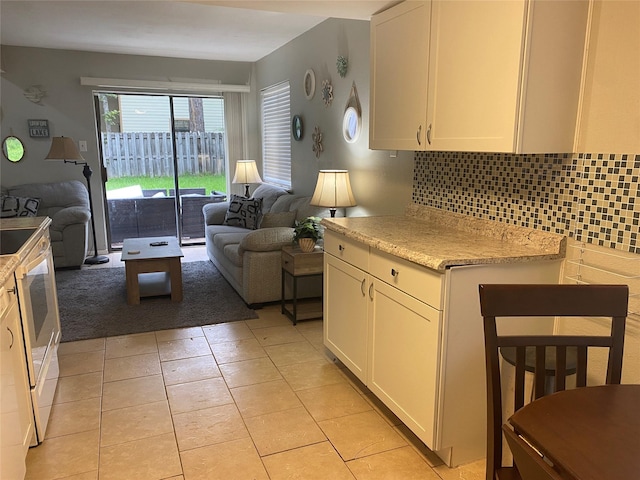 28604 Magnolia Ct, Huntsville, TX 77320 - kitchen with backsplash, open floor plan, white cabinetry, and light tile patterned floors