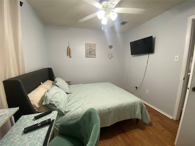 28604 Magnolia Ct, Huntsville, TX 77320 - bedroom featuring a textured ceiling, visible vents, baseboards, a ceiling fan, and wood finished floors