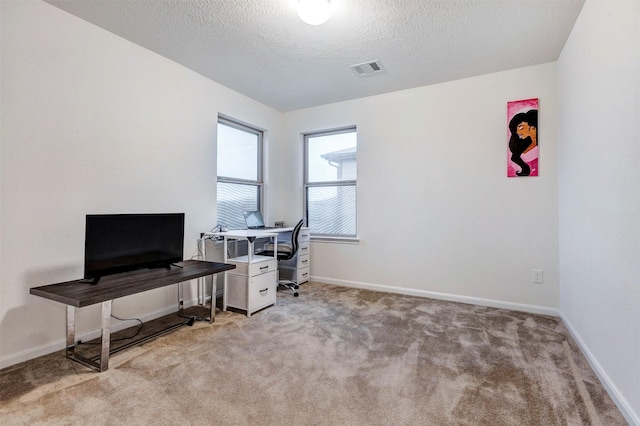 office with light carpet, a textured ceiling, baseboards, and visible vents