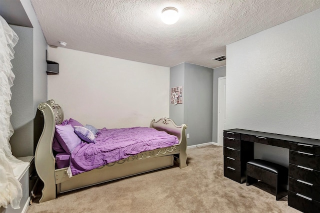 bedroom featuring a textured ceiling, visible vents, and light carpet