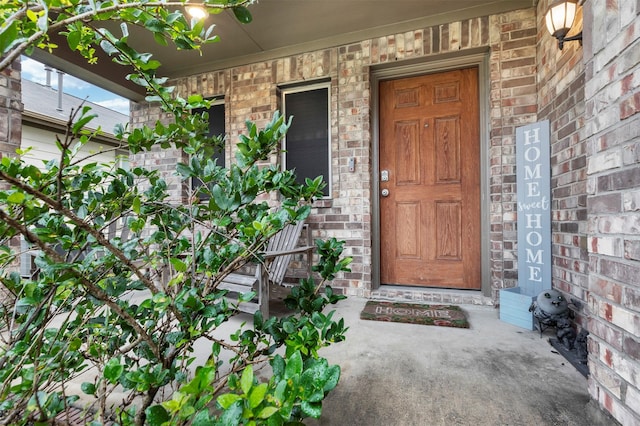 property entrance with covered porch and brick siding