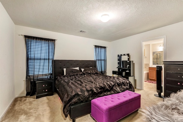 bedroom featuring light carpet, ensuite bath, baseboards, and visible vents