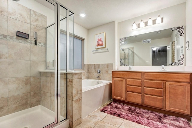 full bathroom with a sink, double vanity, tile patterned floors, a shower stall, and a garden tub