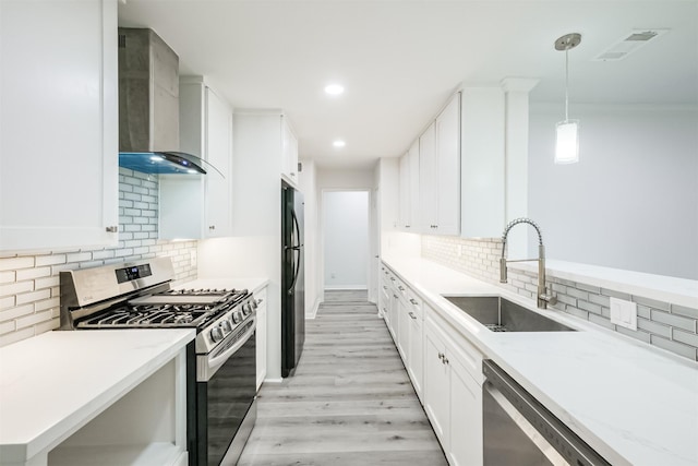 3515 Norris Dr, Houston, TX 77025 - kitchen featuring a sink, light wood-style flooring, backsplash, wall chimney exhaust hood, and appliances with stainless steel finishes