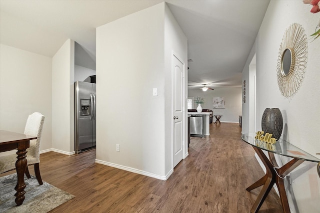 corridor featuring baseboards and wood finished floors