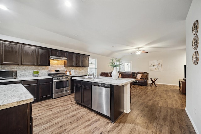 kitchen with light wood-style flooring, stainless steel appliances, light countertops, and a sink