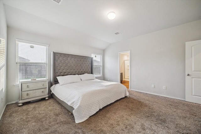 bedroom with carpet floors, visible vents, lofted ceiling, and baseboards