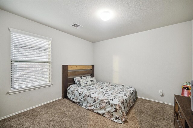 carpeted bedroom featuring baseboards and visible vents