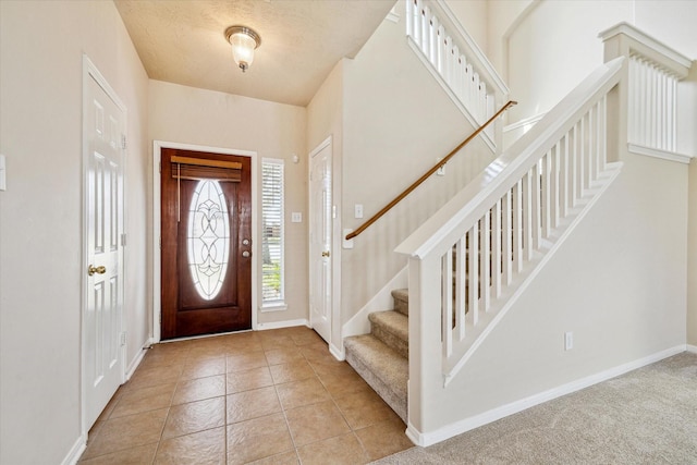 foyer with baseboards, stairs, and light tile patterned flooring