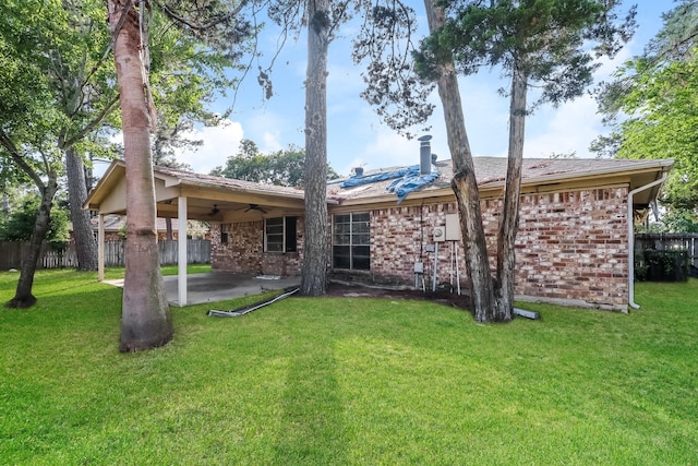 back of house featuring a patio, a ceiling fan, a lawn, and fence