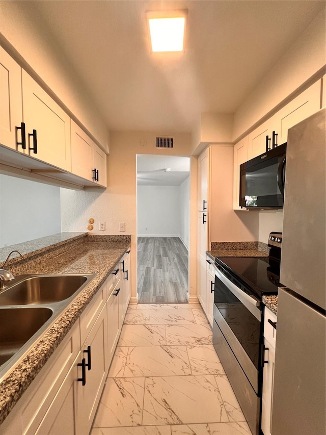 kitchen featuring marble finish floor, visible vents, a sink, appliances with stainless steel finishes, and white cabinetry