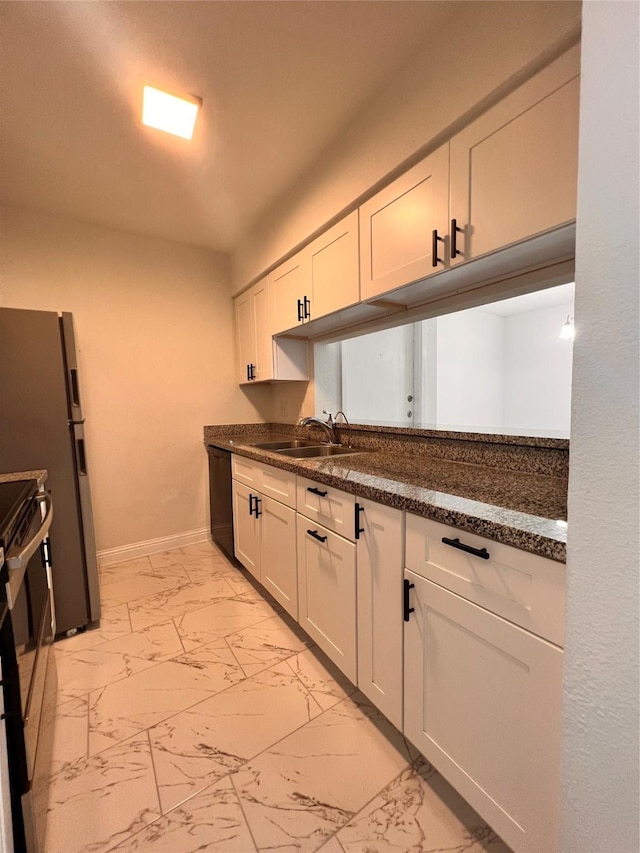 kitchen with black appliances, dark countertops, marble finish floor, and a sink